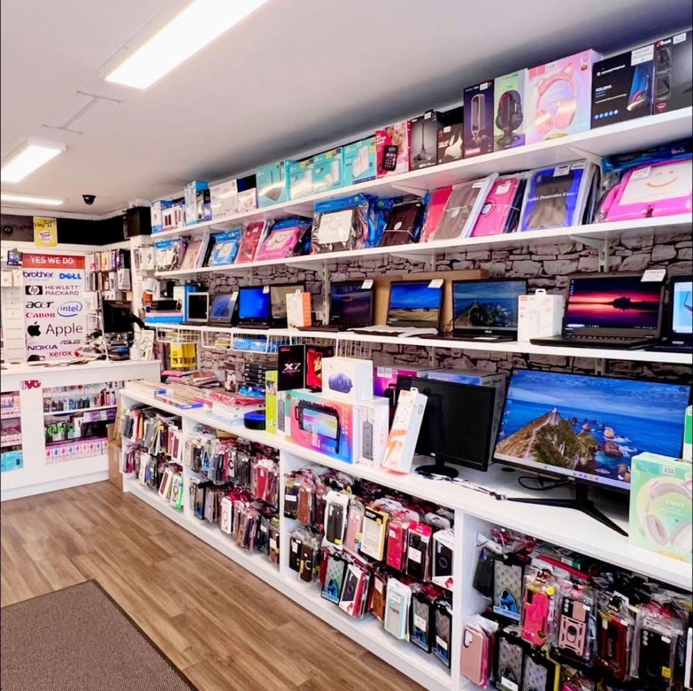 Inside Dungarvan Tech — shelves of phone cases, laptops, monitors and accessories with the brands we repair